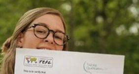 a girl holding her ITA TEFL Certificate