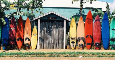 Colorful surfboards lined up on a sidewalk