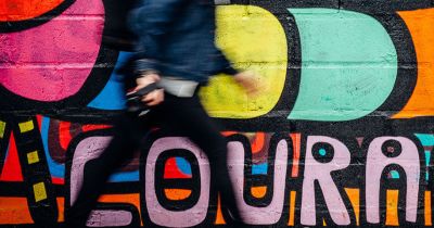 man walking “Courage” in graffiti