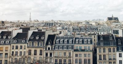 Skyline of parisian buildings with eiffel tower in the background and big white clouds