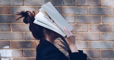 person holding a book over her face