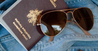 Passport and sunglasses on a jean jacket