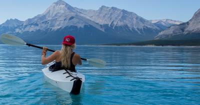 woman in red hat kayaking in crystal blue water