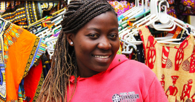 African woman standing in front of her store