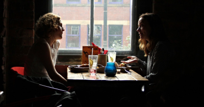 Two women sitting across from each other in a restaurant