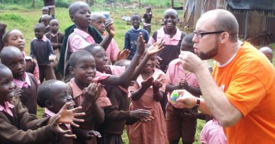 Volunteer blowing bubbles with kids in Africa