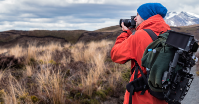 Man taking photos of a mountainous landscape