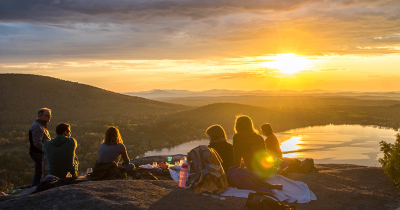 Group of friends having a picnic in the mountains at sunset