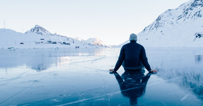 Man sitting on frozen lake in Switzerland