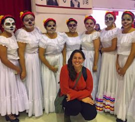 a teacher in Mexico City posing with her students during the Day of the Dead festival
