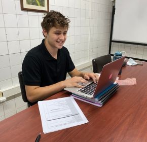 online intern working on his laptop