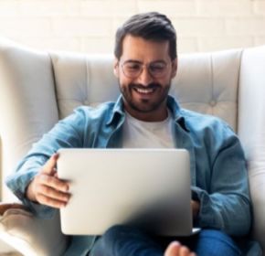 guy sitting on a couch, using a laptop