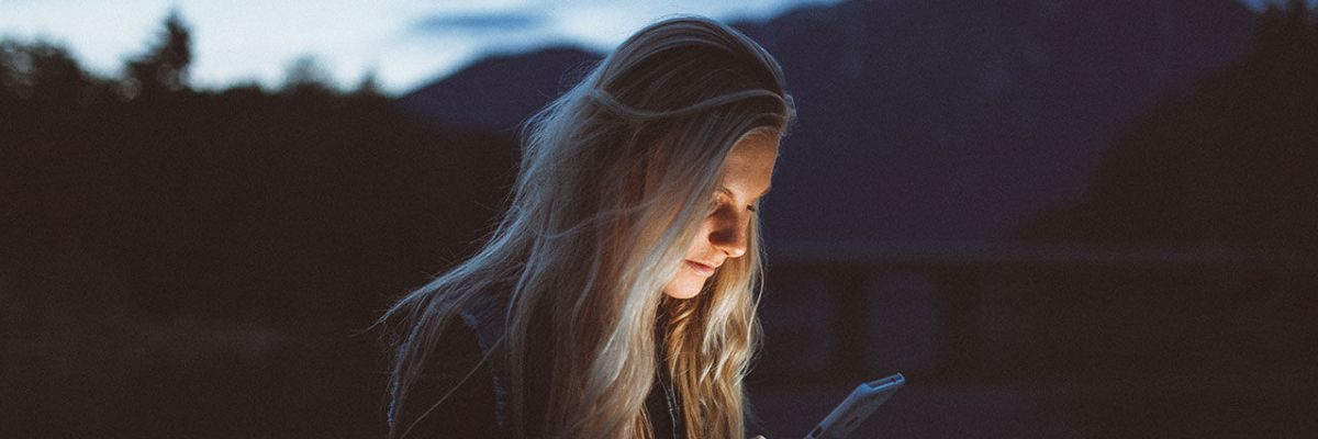 girl looking at phone in the dark with face lit up