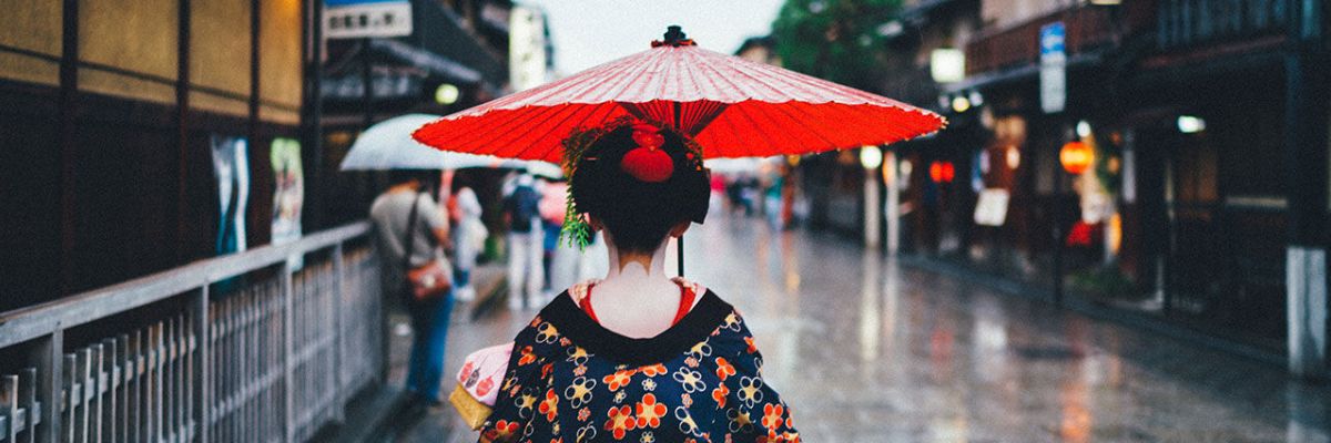 woman with red umbrella standing in street