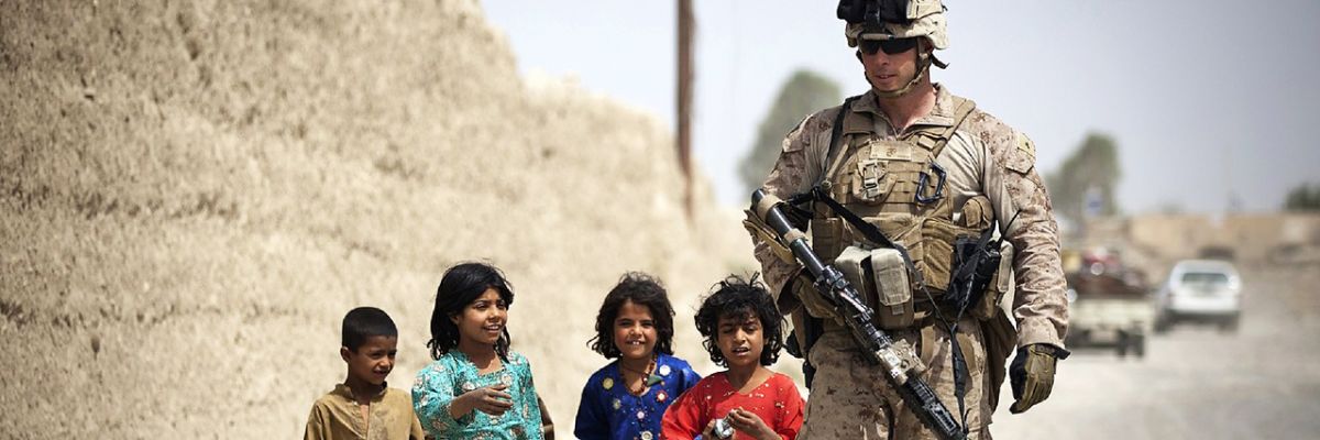 Solider walking with children in the Middle East