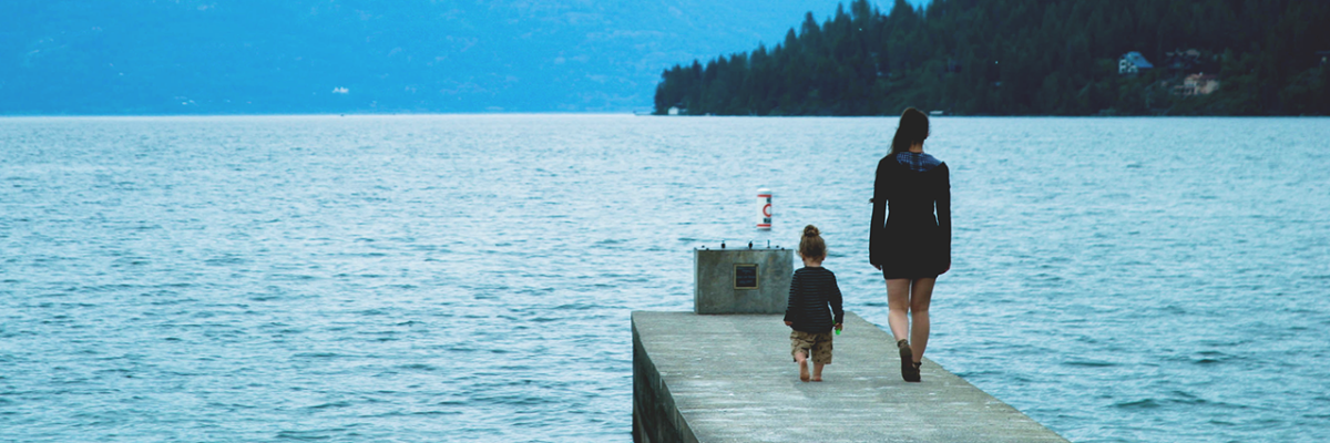 Au pair with child walking down a dock together