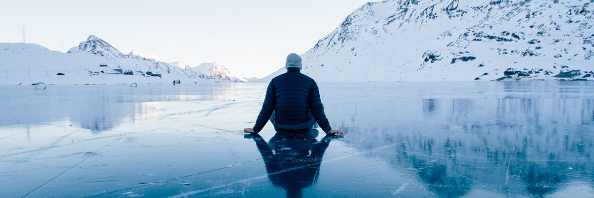 Man sitting on frozen lake in Switzerland