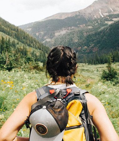 woman backpacking through wilderness