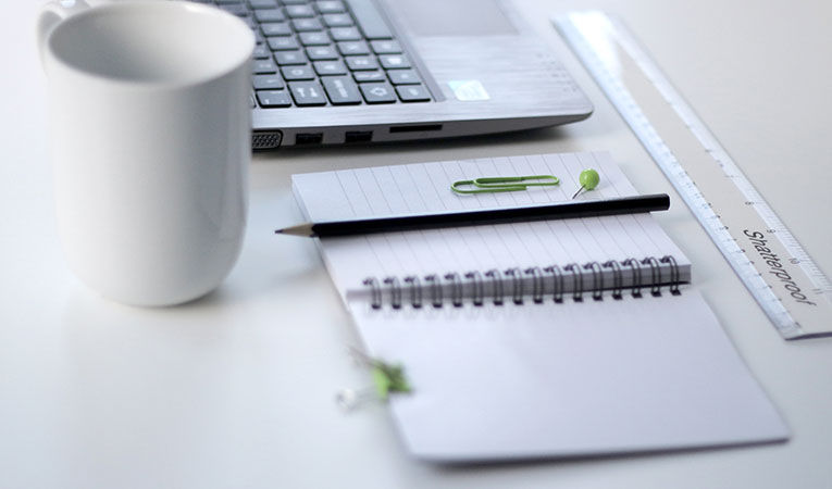 notebook, laptop, and white mug