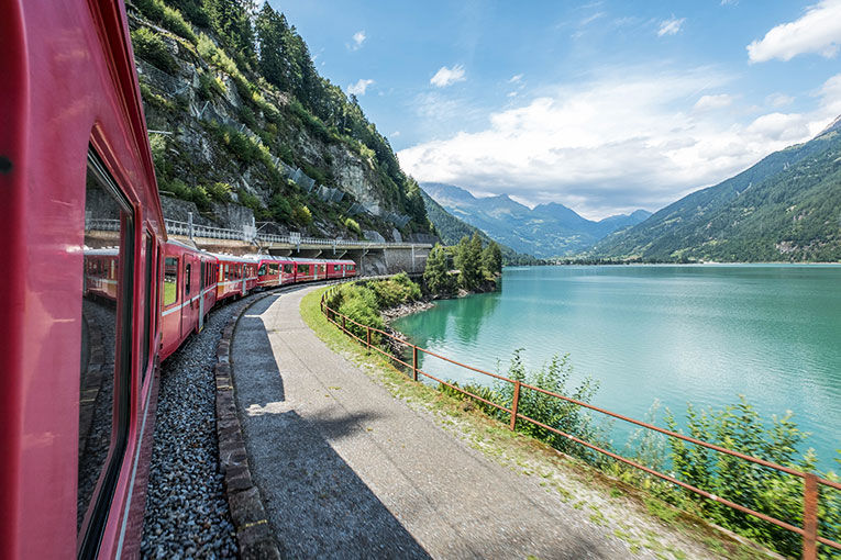 train through the countryside next to a blue lake