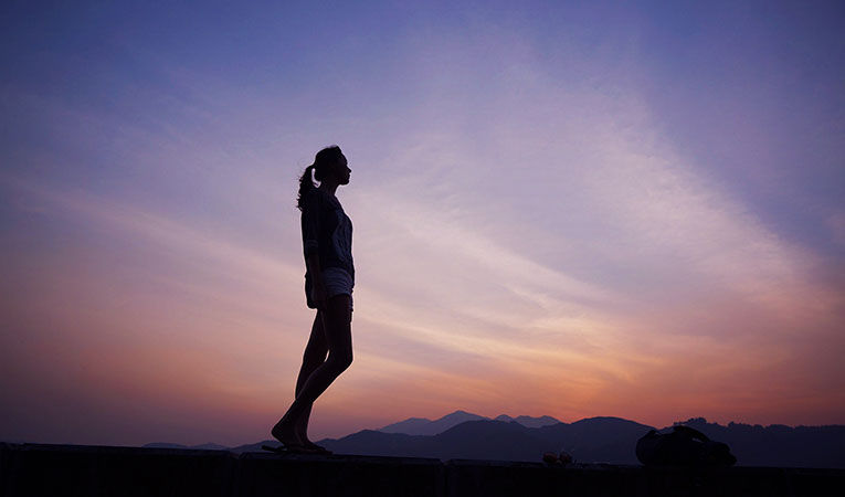 woman standing at sunset
