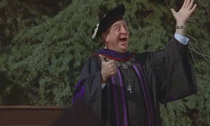 Gif, guy in cap and gown with thumbs up and falling caps