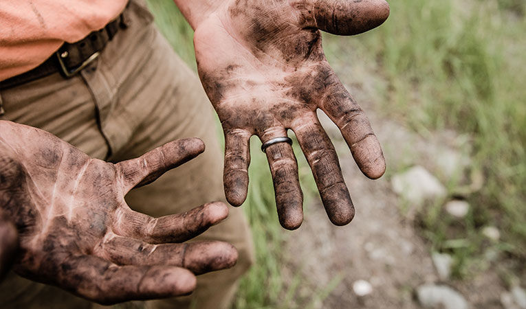 Guy with dirty hands from volunteering abroad as an adult