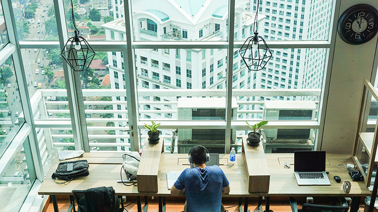 man working in coworking space in Indonesia with large windows