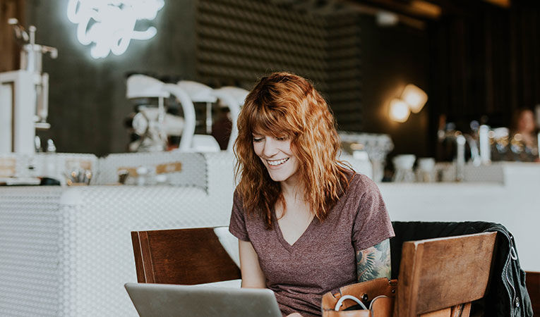 Woman sitting in a cafe looking at laptop