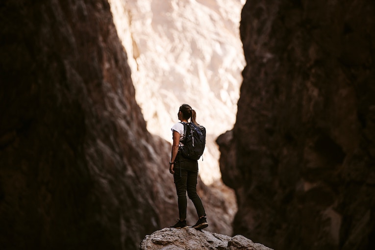 hiker standing on a rock in a canyon
