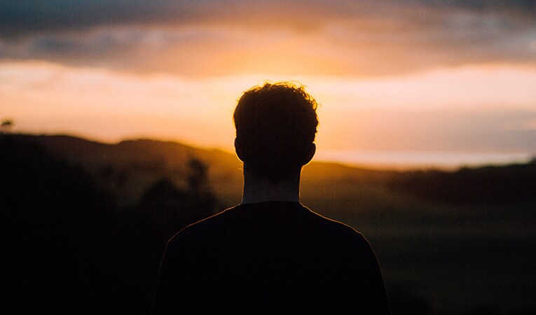 silhouette of man and a sunset weighing the pros and cons of working overseas