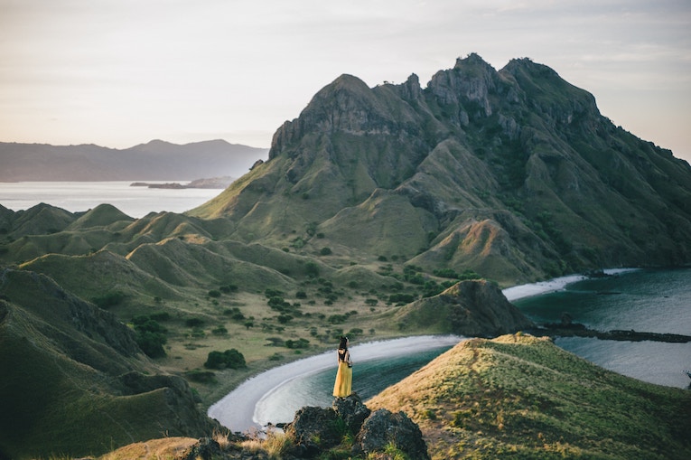 solo traveler on a hilltop at padar island, indonesia