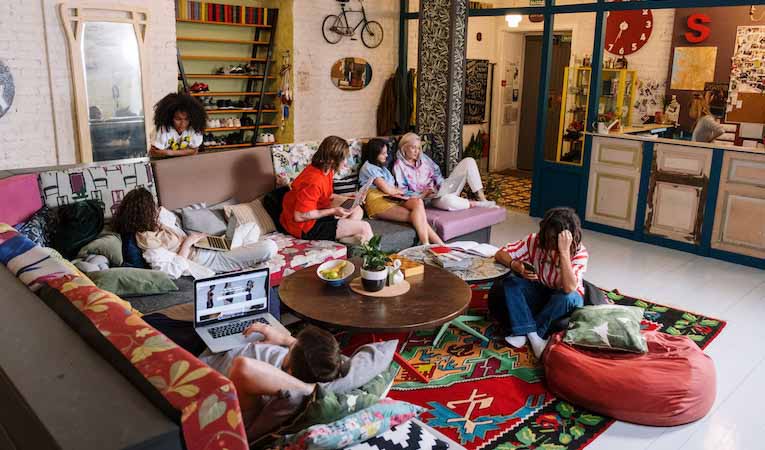 group of travelers hanging out together in a hostel common room