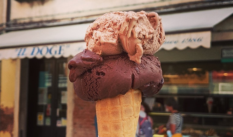person holding up a cone full of chocolate gelato in venice italy