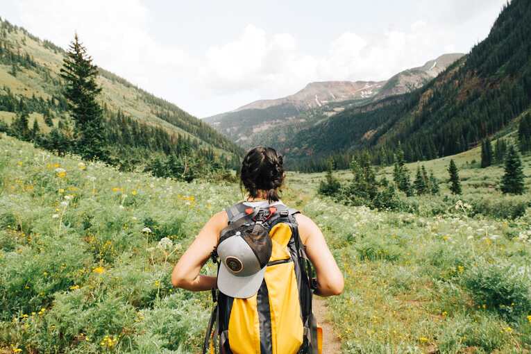 woman backpacking through wilderness