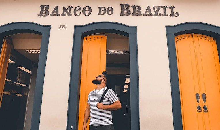 person looking up at sign of Banco Do Brazil
