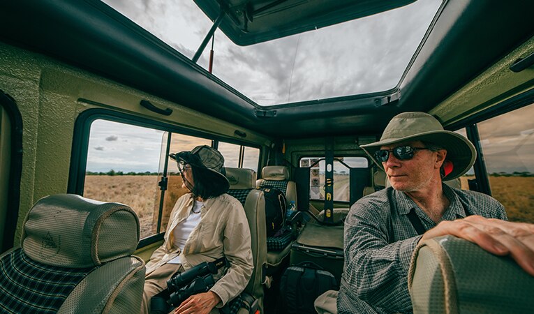 MAn and woman in jeep on safari in Tanzania