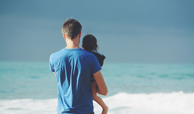 man holding child at beach in Biarritz