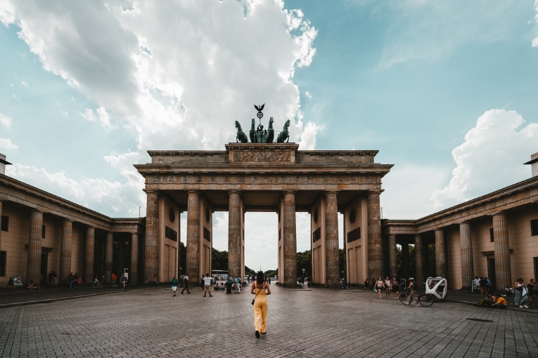person standing on road in front of brandenburg gate