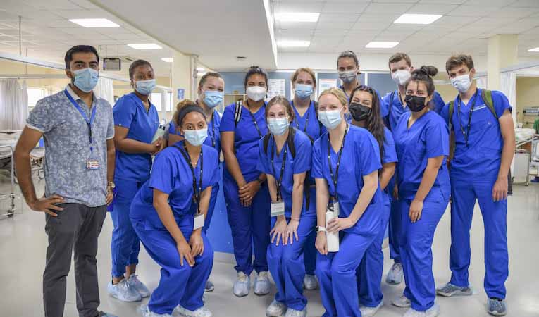 international medical aid participants wearing masks and blue scrubs