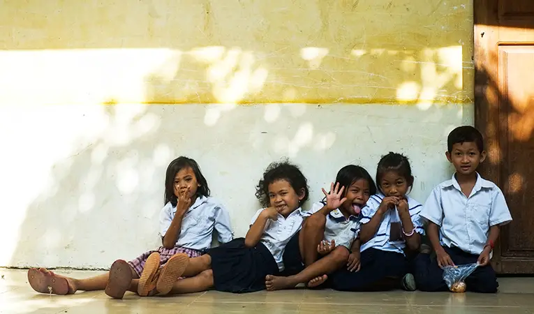 School kids sitting against a wall