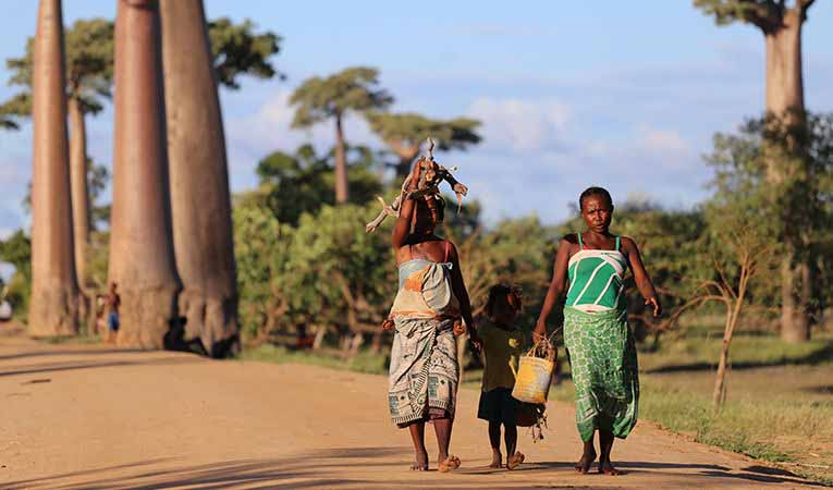 Women walking with children down road in Madagascar