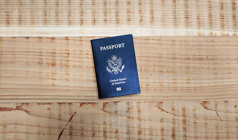american passport sitting on a plain wooden surface