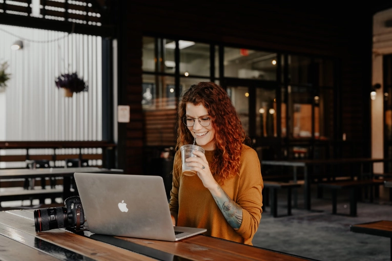 traveler sitting at their laptop with a drink