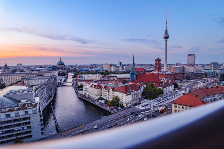 berlin skyline, buildings, and river viewed from behind guardrail