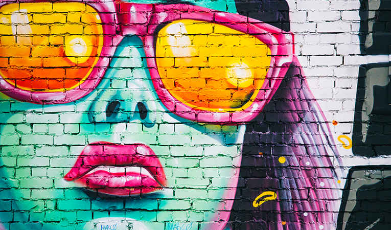 large mural on a wall of a woman in sunglasses