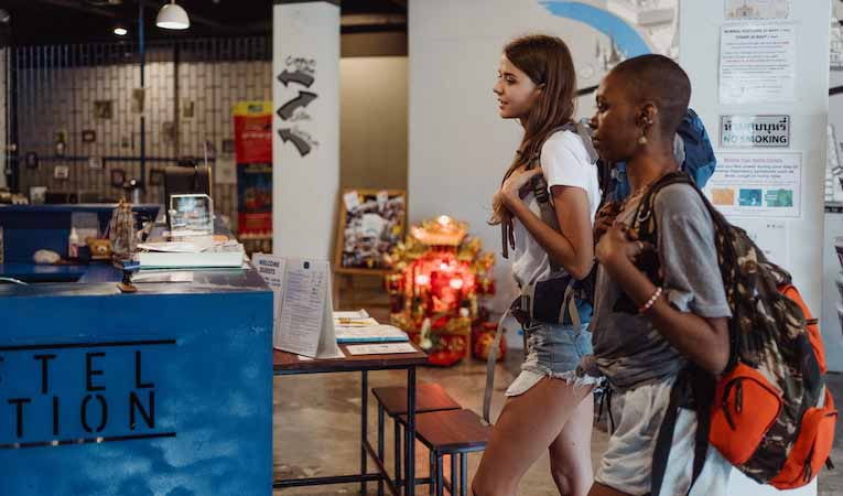 two young backpackers checking into a hostel