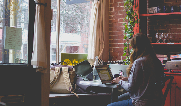 Woman working on her laptop in a cafe