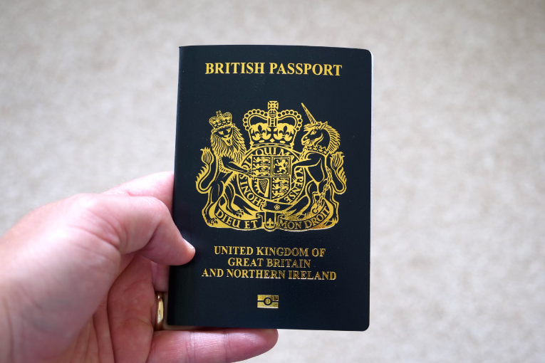 hand holding closed british passport