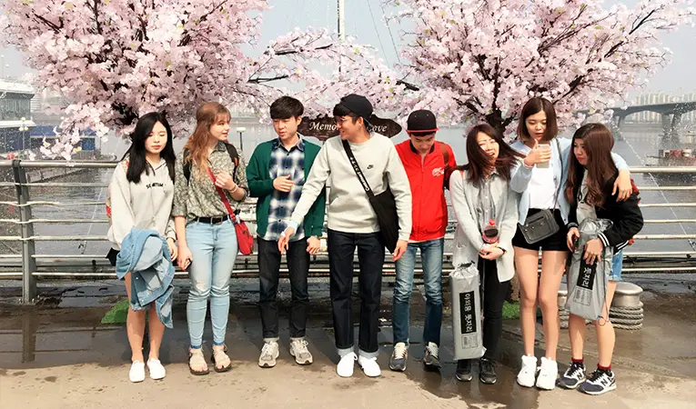 Students standing together in front of blossoming trees